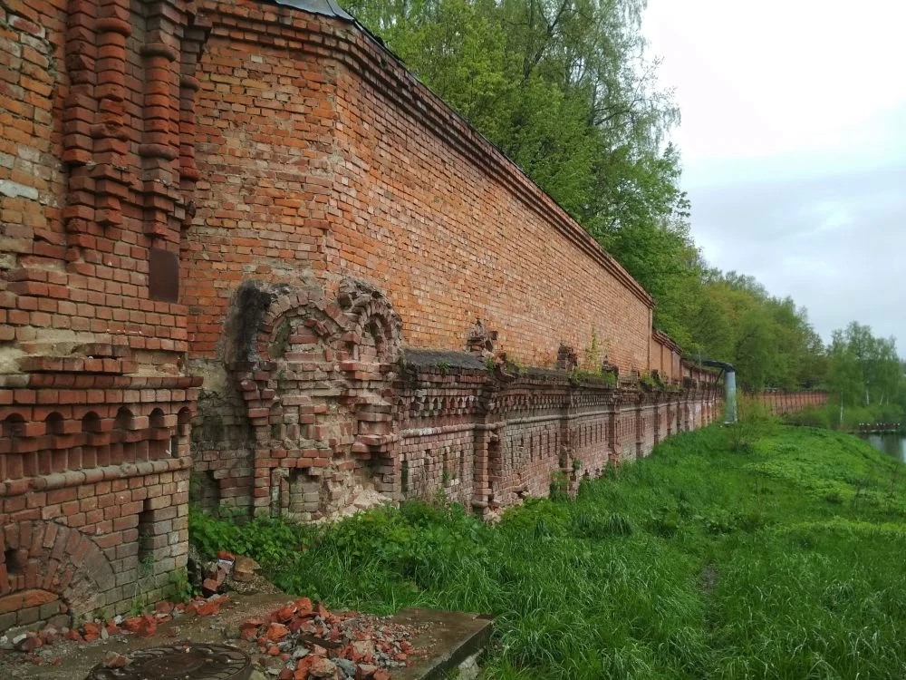 Стены разрушаются, сползая в пруд